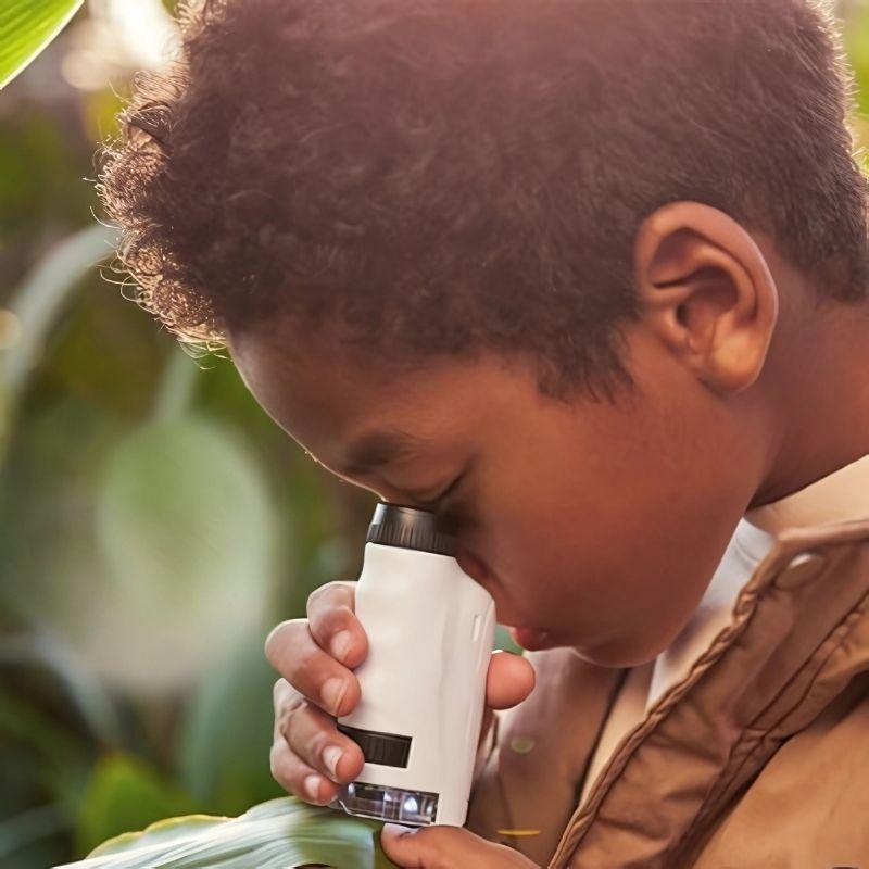 un-garçon-observe-une-feuille-de-plante-avec-son-microscope-enfant