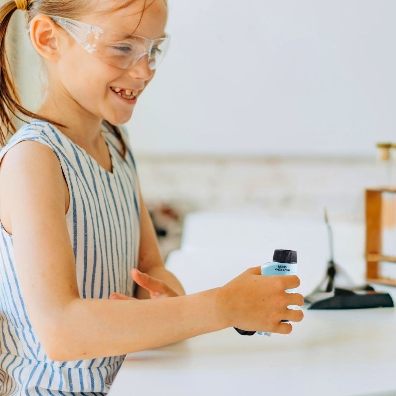 une-fille-de-10-ans-utilise-un-microscope-bleu