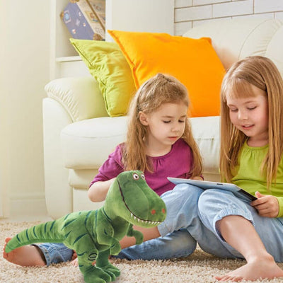 des-fillettes-lisent-un-livre-à-côté-de-leur-peluche-dinosaure-vert-dans-le-salon