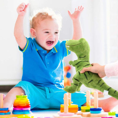 un-bébé-chandail-bleu-heureux-de-voir-une-peluche-dinosaure-que-maman-lui-ten