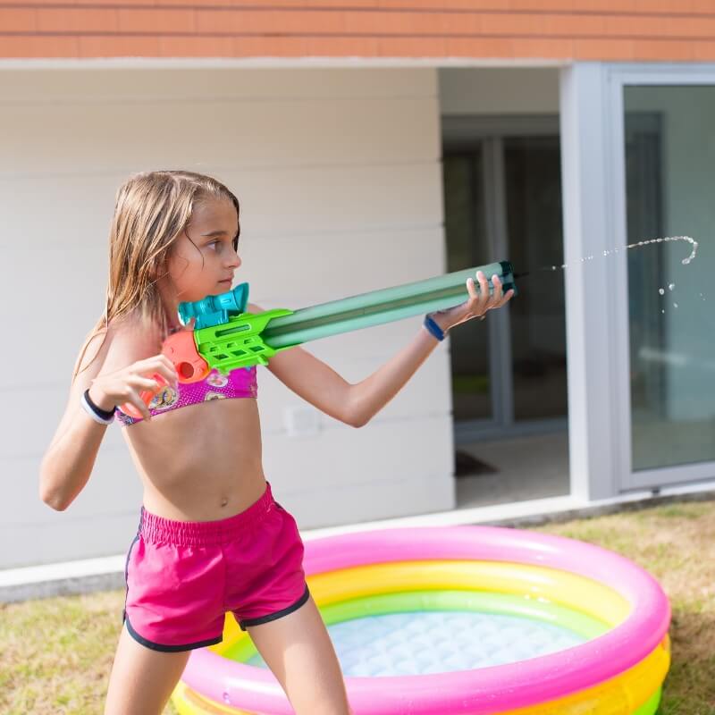 une-fille-arrose-avec-son-jouet-de-plage