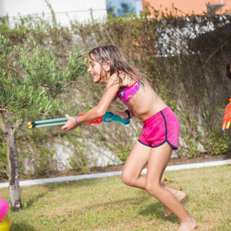 une-fillette-fait-la-bataille-d'eau-dans-le-jardin