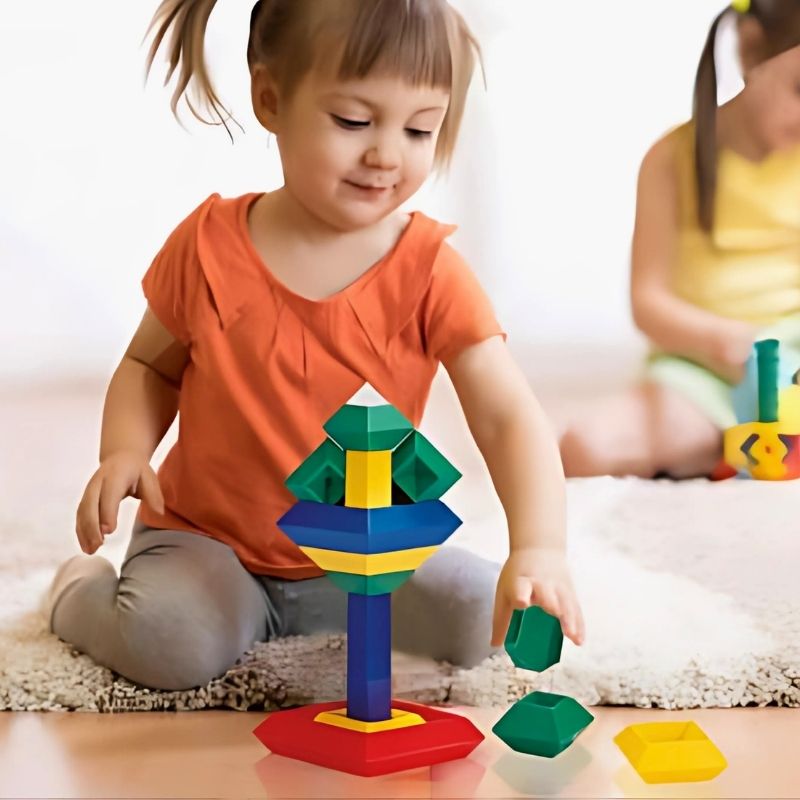 Fille 3 ans heureuse joue à un jeu de construction