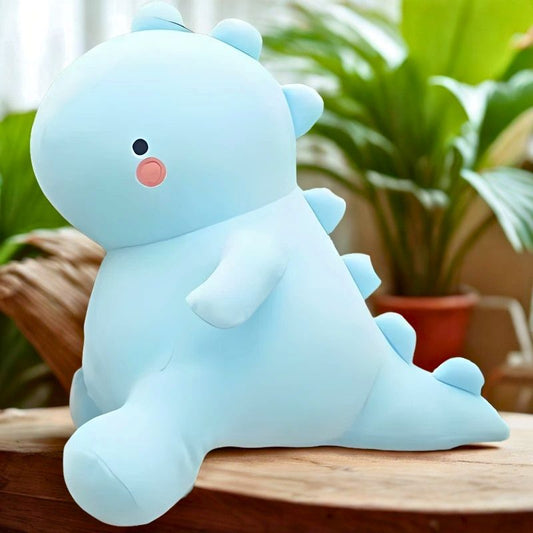 Peluche dinosaure dodue bleu poudre sur table basse
