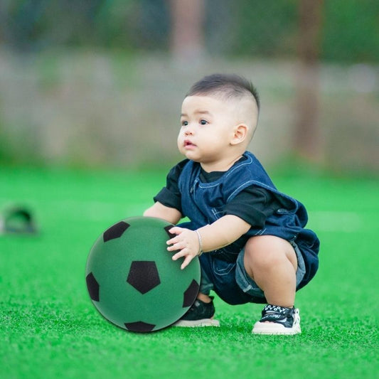 un-bébé-joue-avec-son-ballon-de-foot-vert