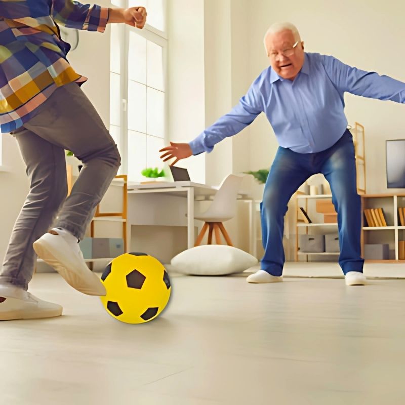 un-enfant-joue-au-foot-avec-son-grand-père-dans-la-maison