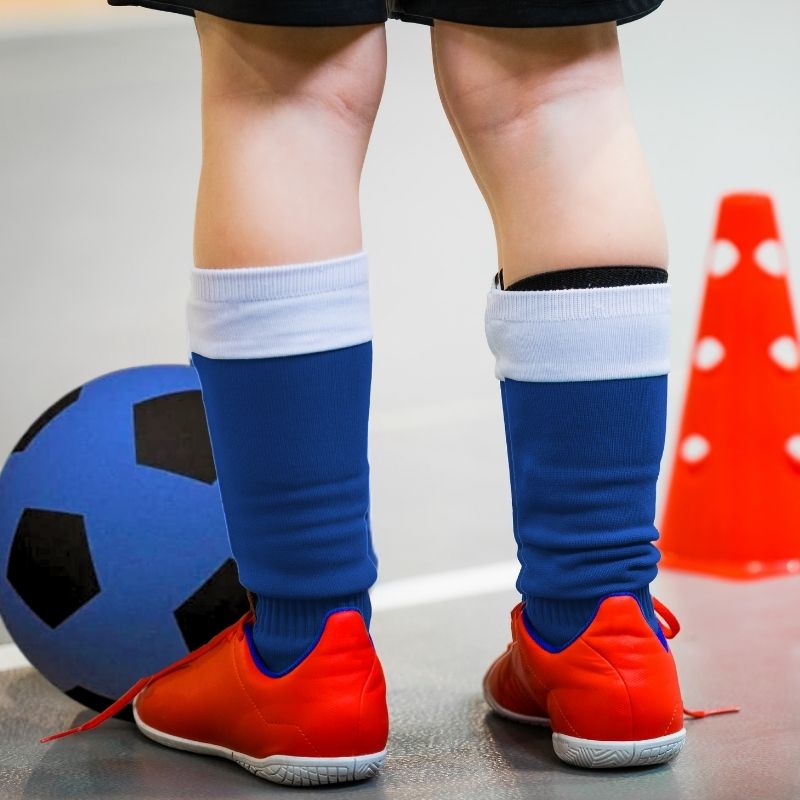 un-garçon-football-espadrilles-rouges-petit-cône