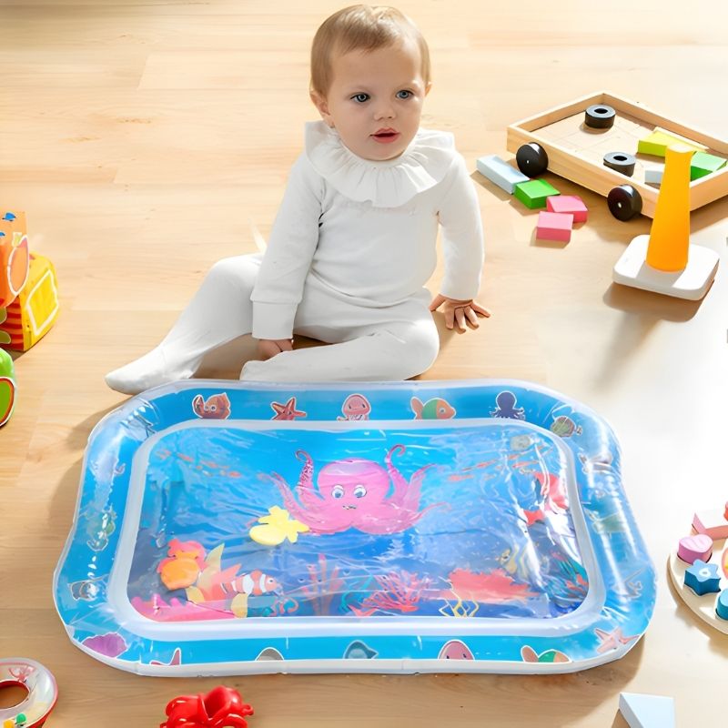 bébé fille assise devant un tapis d'eau avec ses jouets