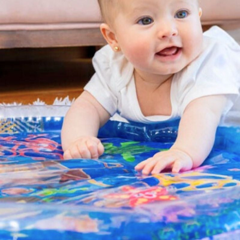 bébé fille souriante jouant avec son tapis d'eau bébé