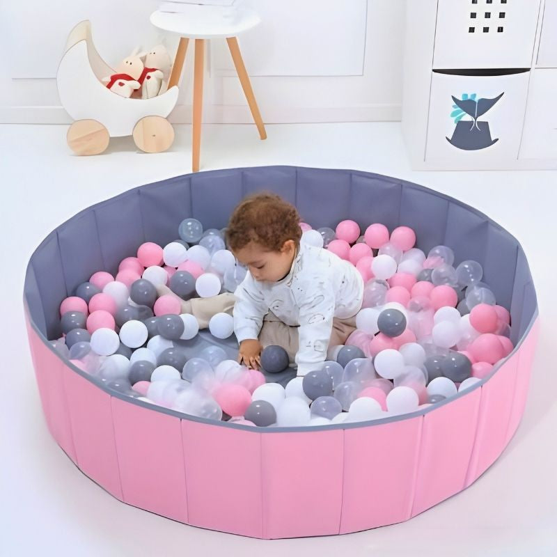 bébé joue dans sa piscine a balle bebe rose pliante