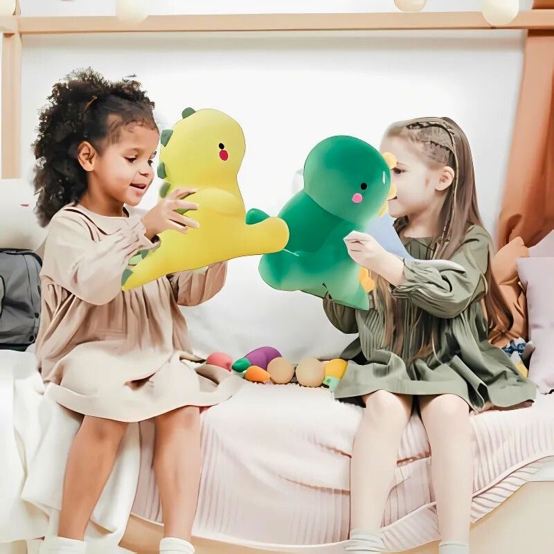 deux fillettes 6 ans jouent avec leur peluche dinosaure