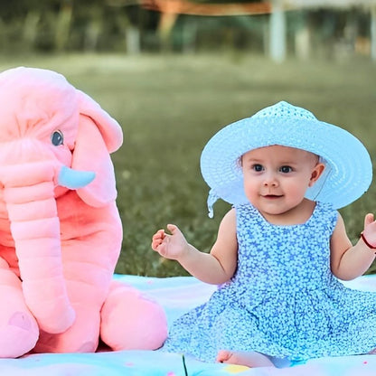 bebe-fille-avec-robe-bleue-et-chapeau-sur-une-nappe-avec-sa-peluche-elephant-rose
