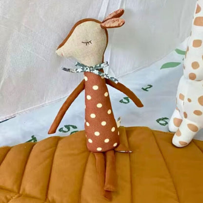 peluche-en-forme-de-cerf-au-poil-roux-et-a-la-forme-elancee-sur-un-coussin-brun