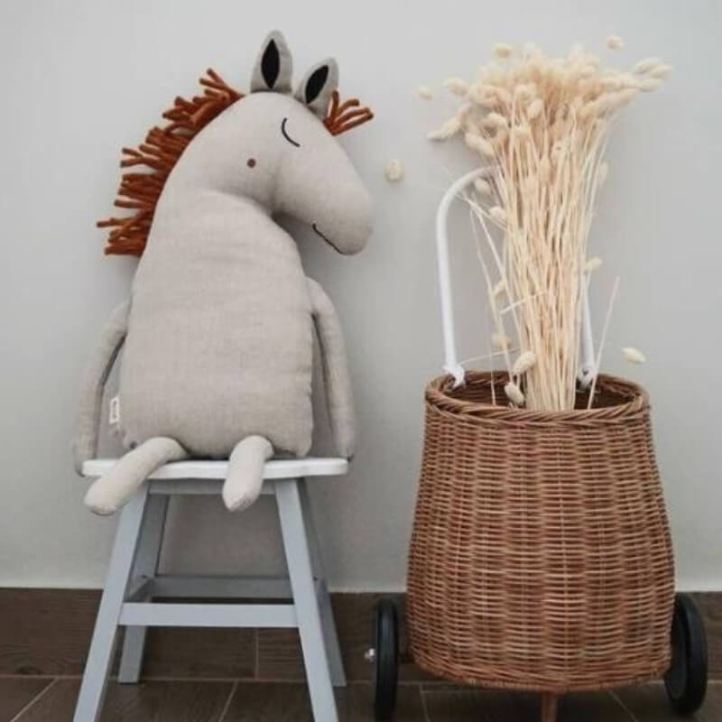 licorne-beige-en-peluche-sur-un-banc-a-cote-d_un-panier-en-osier