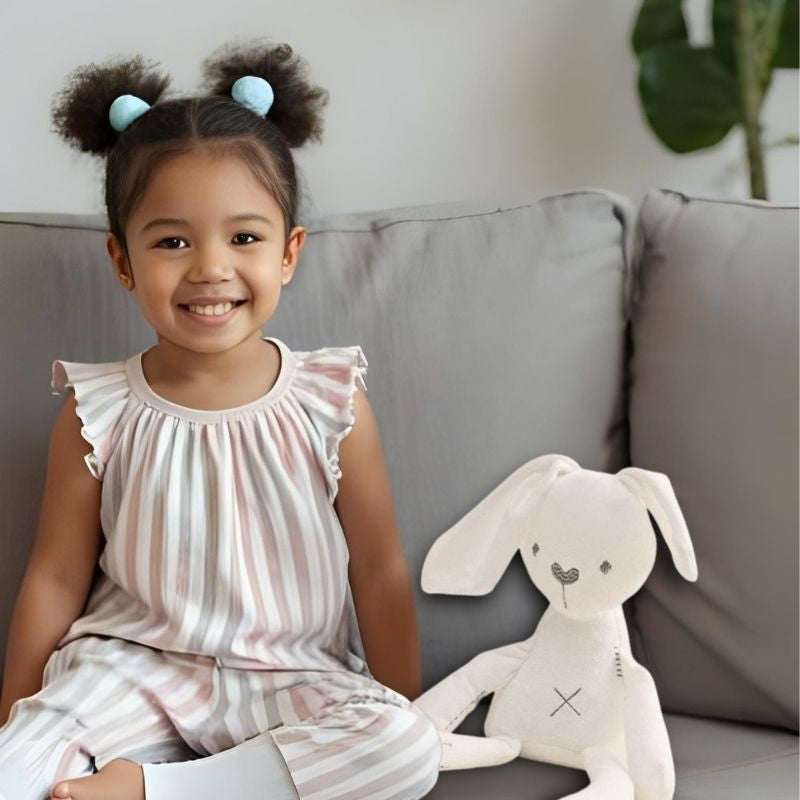 fille 4 ans sur canape avec peluche lapin blanc