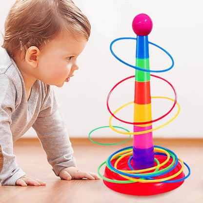 un-bebe-qui-regarde-une-tour-de-gobelets-multicolores-sur-le-sol-avec-des-anneaux-colores-autour