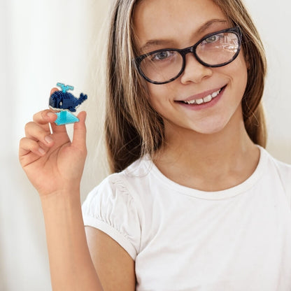 une-fille-t-shirt-blanc-lunette-tient-une-figurine-baleine-bleue