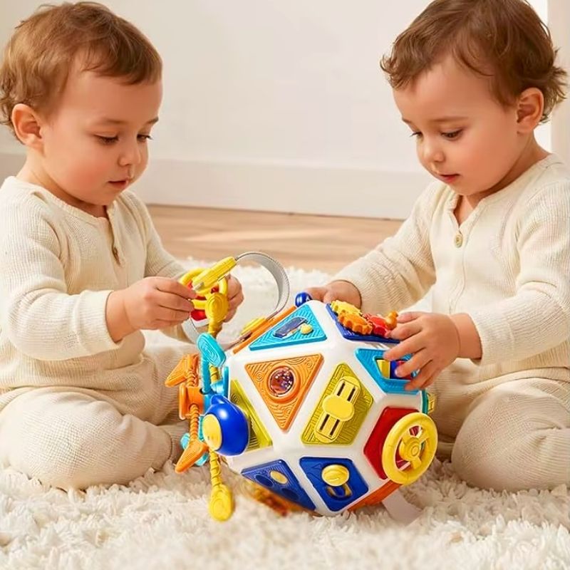 jouet bébé 1 an des jumeaux s'amuse avec une balle sensorielle