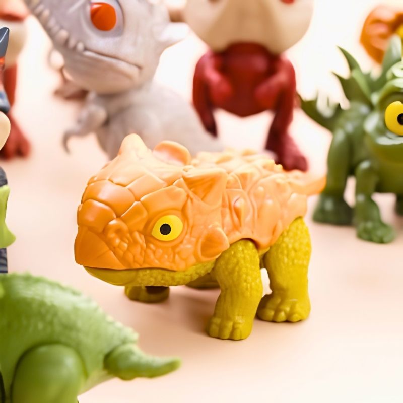 jouet dinosaure petit quadripède orange et vert yeux jaunes