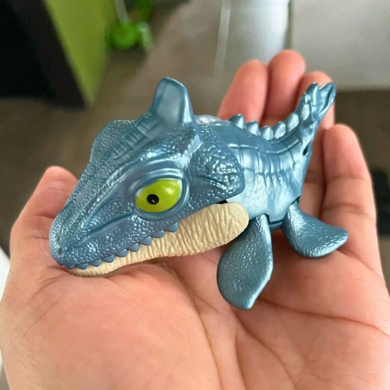 jouet dinosaure petite figurine colorée tenant dans une main