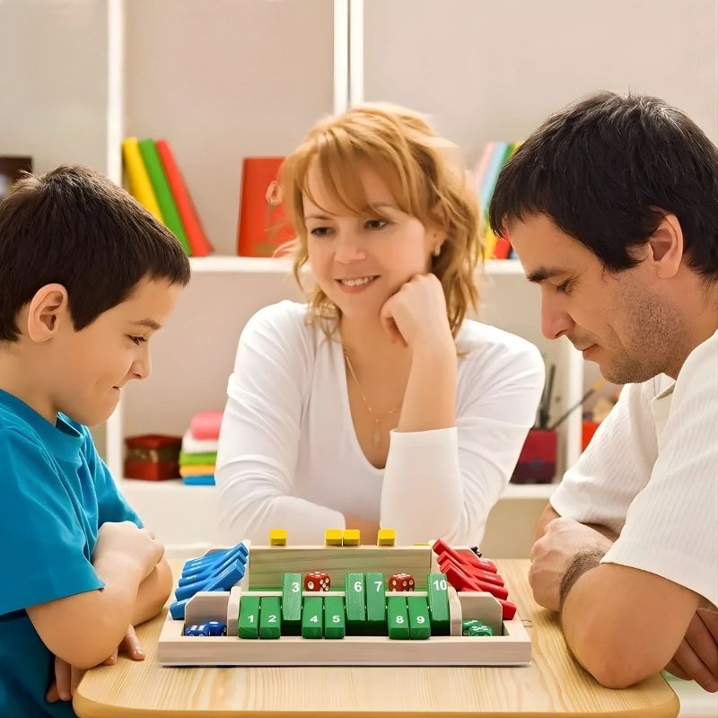 maman regarde son fils qui joue à jeu de société contre papa