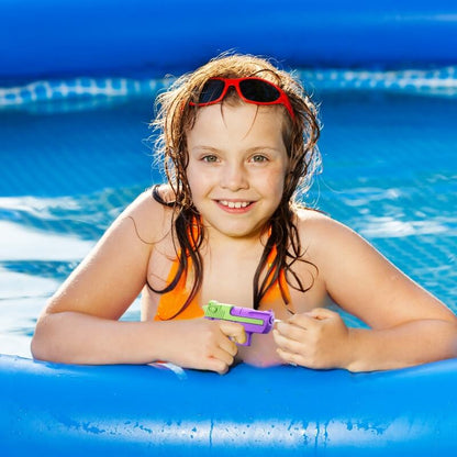 une-fille-heureuse-dans-sa-piscine-avec-son-mini-pistolet-a-eau-violet-et-vert