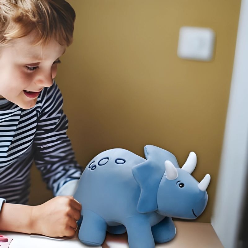 peluche dinosaure garçon de 10 ans avec sa peluche triceratops bleue