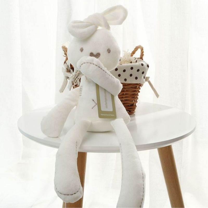 peluche lapin mince et elance sur une table blanche