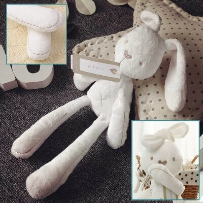 lapin-élancé-aux-grandes-oreilles-étendu-sur-un-tapis-gris-et-adossé-à-un-coussin-beige