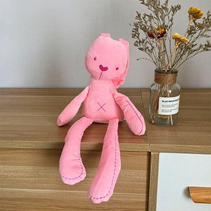 peluche lapin rose déposée sur un bureau brun