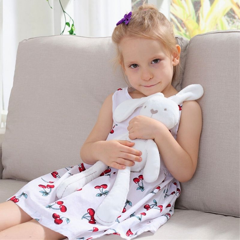 petite fille heureuse avec sa peluche lapin blanc