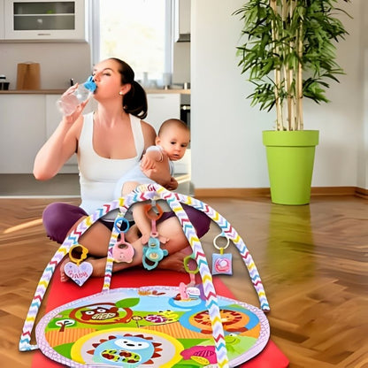 tapis d'éveil bébé sur tapis de yoga rouge maman boit