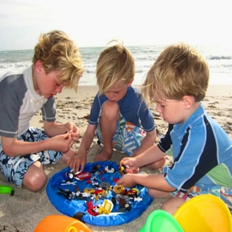trois-garçons-font-des-lego-a-la-plage