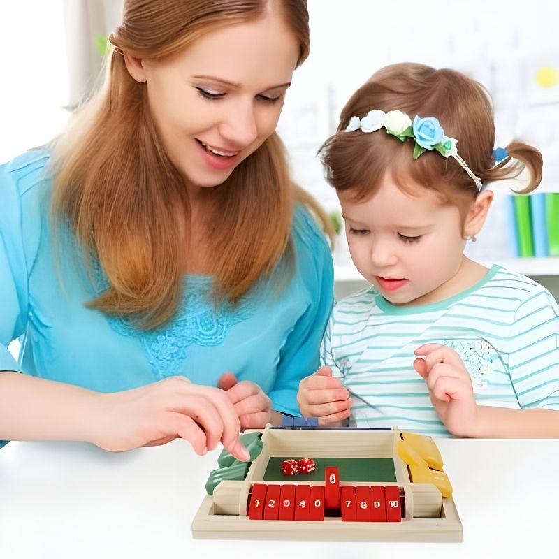 une maman et sa fille 4 ans jouent à un jeu de société famille